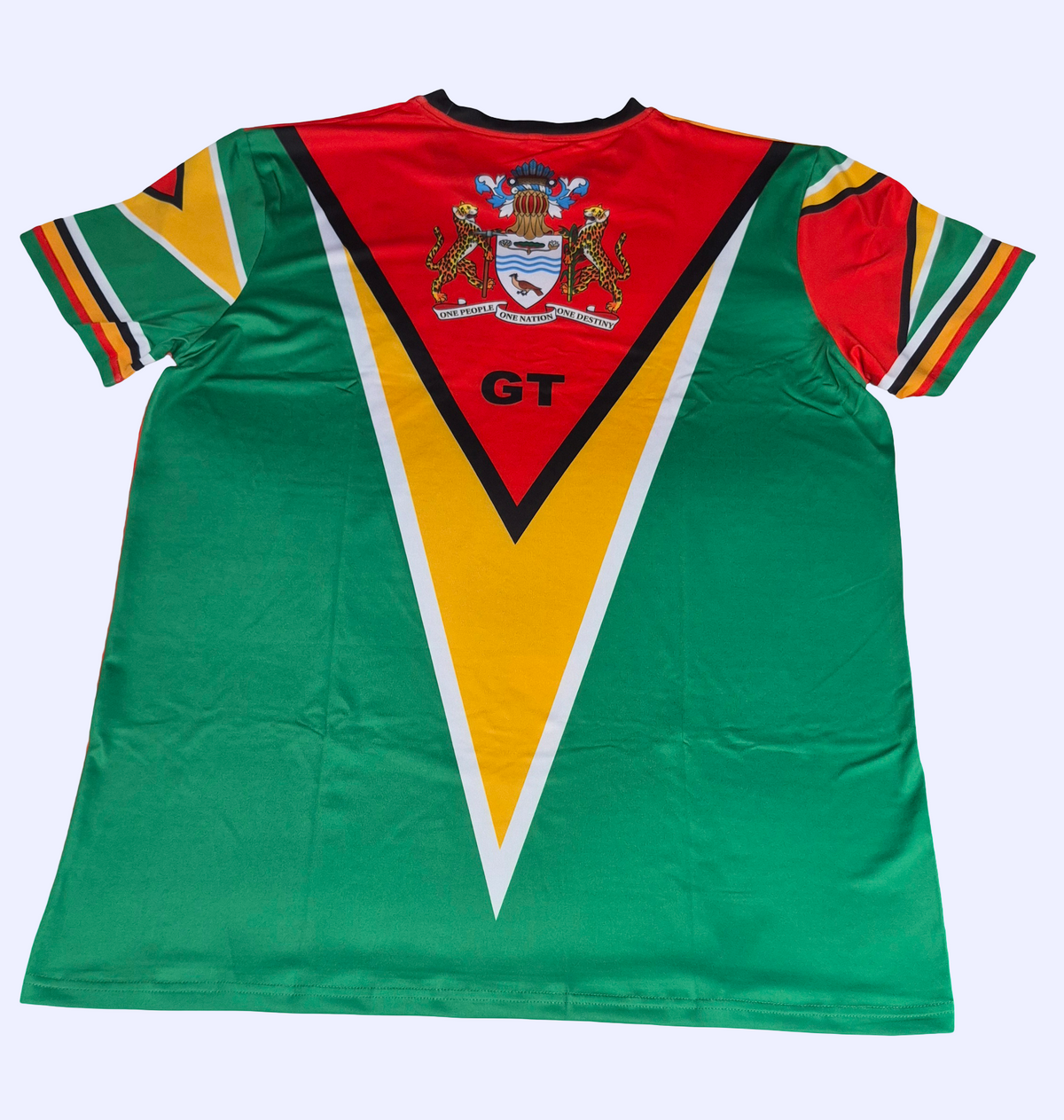 A short-sleeve athletic Guyana jersey laid flat, featuring a bold green body with a large red and yellow V-shaped graphic on the front, bordered by white stripes. The sleeves have red, yellow, and green stripes.