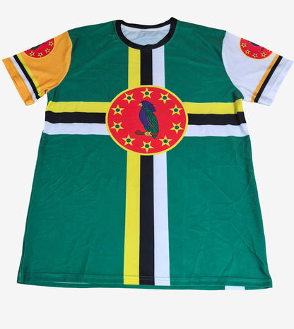 A short-sleeve t-shirt featuring the flag of Dominica, with a green body, yellow and black vertical stripes, a white horizontal stripe, and a central red circle containing a blue bird and yellow stars. The sleeves have yellow and white sections with red and yellow circular details.