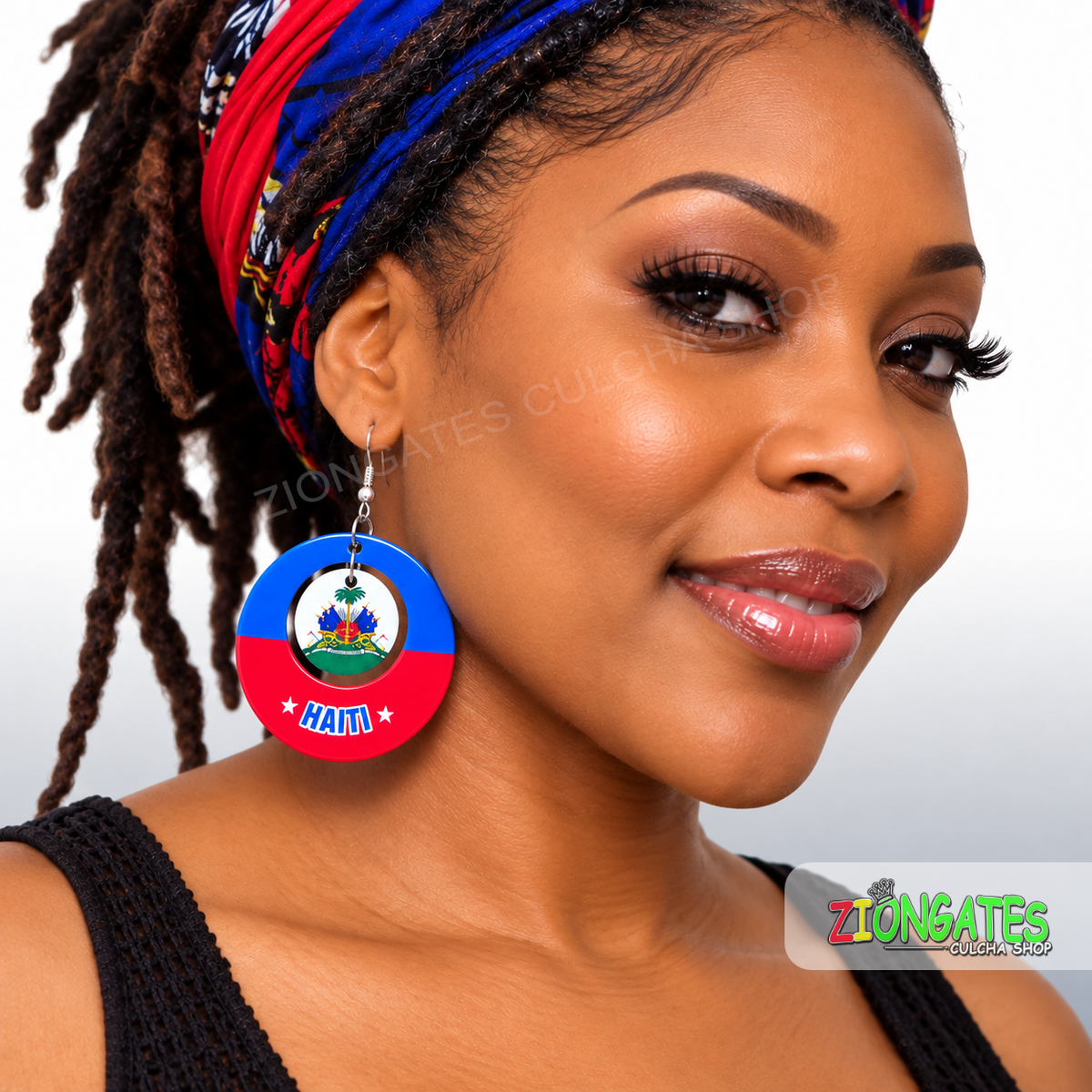 A close-up of a woman wearing a pair of round wooden Haiti earrings. The earrings are colored like the Haitian flag with a blue top half, red bottom half, and the national coat of arms in the center, with the word 'HAITI' printed in white on the red section.