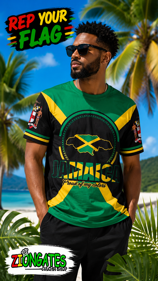 A man wearing a Jamaica-themed graphic t-shirt with green, yellow, and black colors, standing on a tropical beach with palm trees and blue sky in the background. The shirt features a circular Jamaica map graphic with the Jamaican flag and the word 'JAMAICA' printed below.
