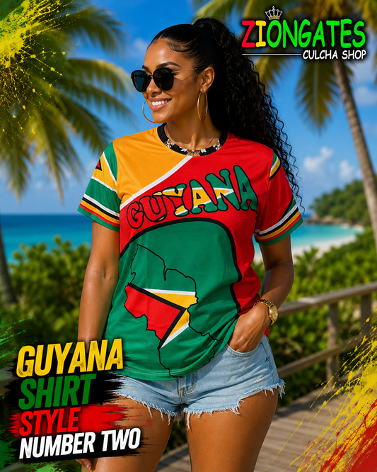 A woman wearing a colorful short-sleeve t-shirt with a Guyana graphic, standing on a beach with palm trees and ocean in the background. The shirt features red, green, yellow, and white sections with 'GUYANA' written across the chest.